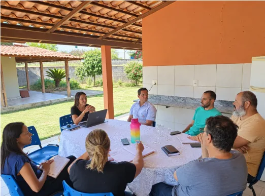 Roberta Zago em reunião técnica analisando mapas com equipe